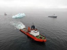Vessels tug an iceberg over a single course in parallel to each other at a safe distance